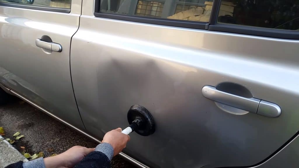 Suction using plunger to take dent out